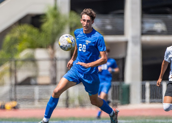 Soccer Player for Santa Monica in a blue jersey looking at a soccer ball on the field.
